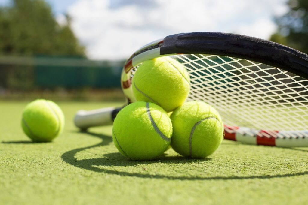 photo of tennis balls and racquet